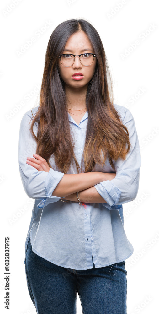 Young asian business woman wearing glasses over isolated background skeptic and nervous, disapproving expression on face with crossed arms. Negative person. Young asian business woman wearing glasses over isolated background skeptic and nervous, disapproving expression on face with crossed arms. Negative person.