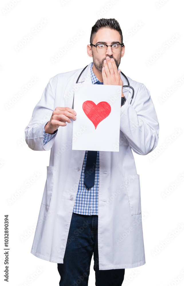 Handsome young doctor man holding paper with red heart over isolated background cover mouth with hand shocked with shame for mistake, expression of fear, scared in silence, secret concept Handsome young doctor man holding paper with red heart over isolated background cover mouth with hand shocked with shame for mistake, expression of fear, scared in silence, secret concept
