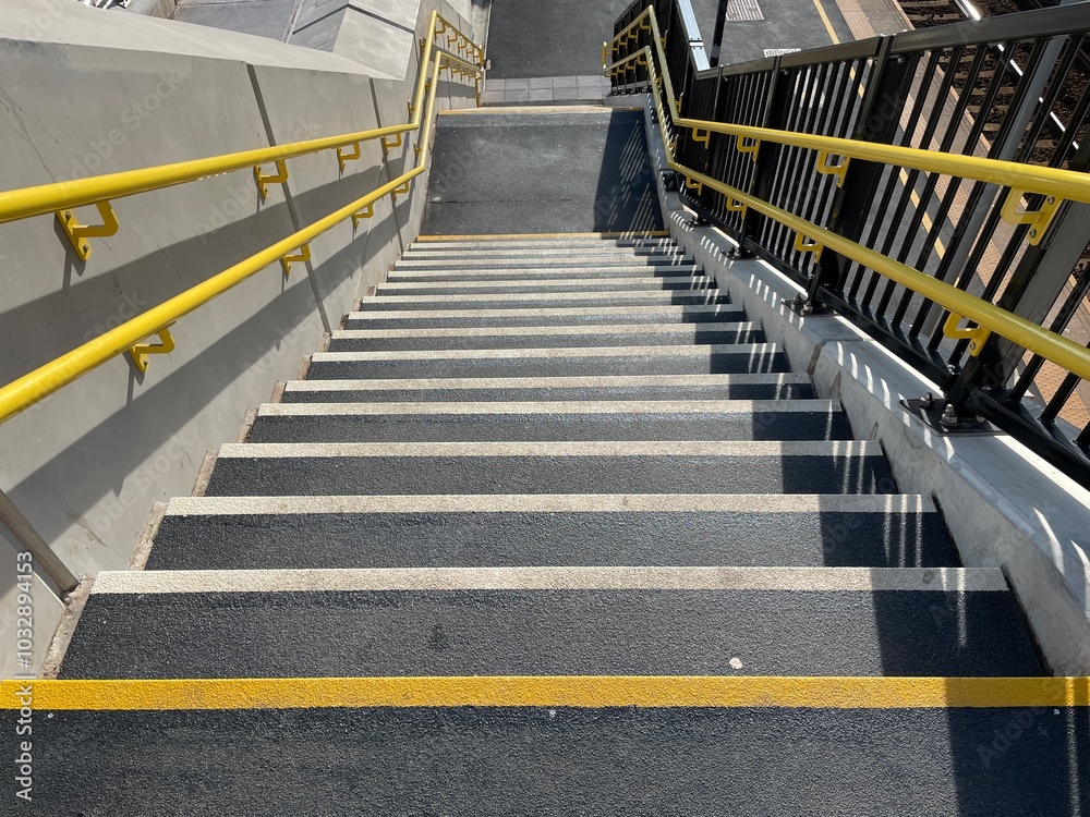 Yellow handrails and non-slip stairs on new staircase at railway station
