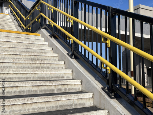 Bright yellow handrails, railings and non-slip stairs on new staircase at railway station