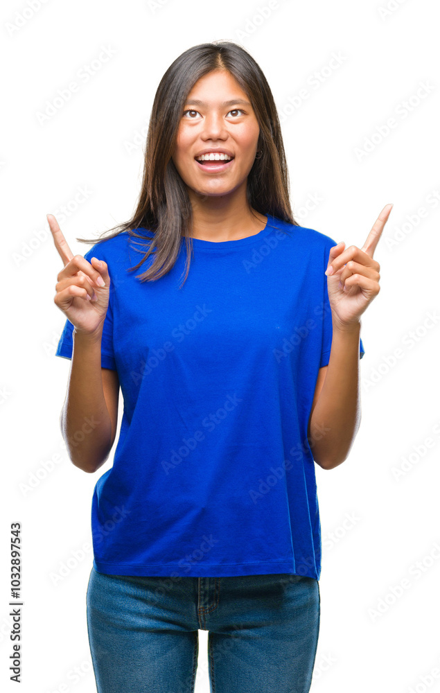 Young asian woman over isolated background amazed and surprised looking up and pointing with fingers and raised arms. Young asian woman over isolated background amazed and surprised looking up and pointing with fingers and raised arms.