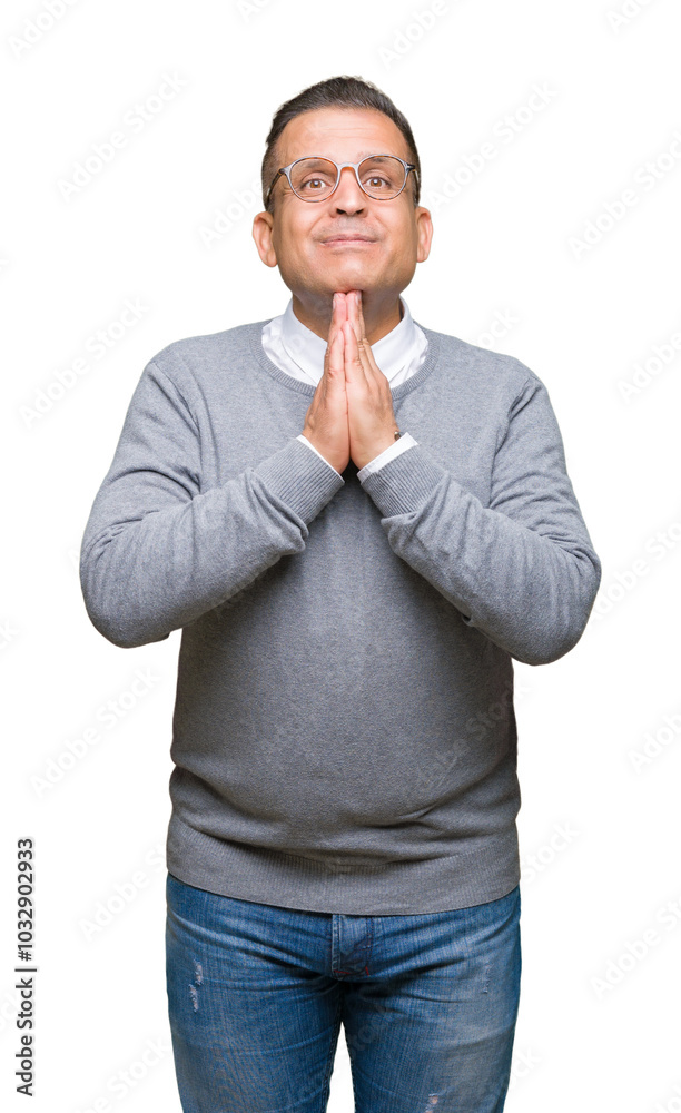 Middle age bussines arab man wearing glasses over isolated background praying with hands together asking for forgiveness smiling confident. Middle age bussines arab man wearing glasses over isolated background praying with hands together asking for forgiveness smiling confident.