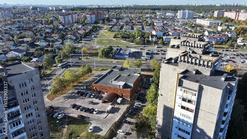 Minsk, Belarus - 27.10.2024: Dense building of a modern large Belarusian city. Neighborhood of one-storey huts, cottages and multi-storey residential buildings. View of the city of Minsk from a height