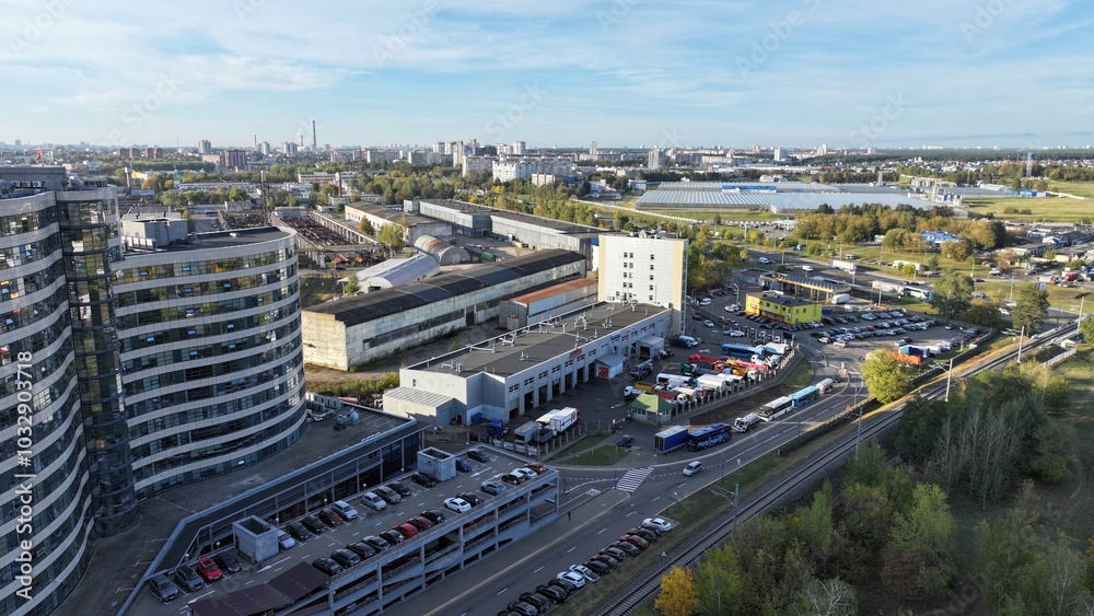 Obraz premium Minsk, Belarus - 27.10.2024: The outskirts of Minsk in the fall, a large metropolis, a view from a height. The area behind the ring road of Minsk. Storage warehouses, repair depots, private buildings.