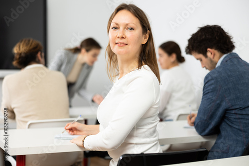 Diligent adult woman attending lecture in university photo