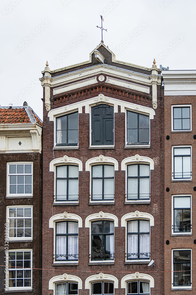 Fototapeta premium Colorful old buildings with gable rooftops and hooks along Herengracht canal. In XVII century richest merchants, most influential regents and mayors lived on this canal. Amsterdam, the Netherlands.