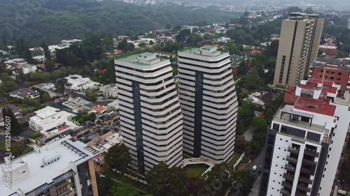 Drone flying between buildings on a cloudy day in Guatemala City, Central America