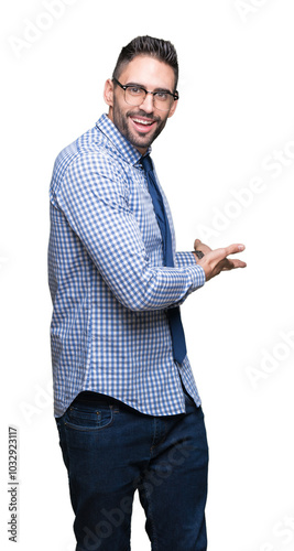 Young business man wearing glasses over isolated background Inviting to enter smiling natural with open hand