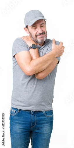 Handsome middle age hoary senior man wearing sport cap over isolated background Hugging oneself happy and positive, smiling confident. Self love and self care