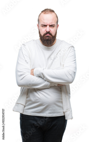 Young caucasian hipster man wearing sport clothes over isolated background skeptic and nervous, disapproving expression on face with crossed arms. Negative person. photo