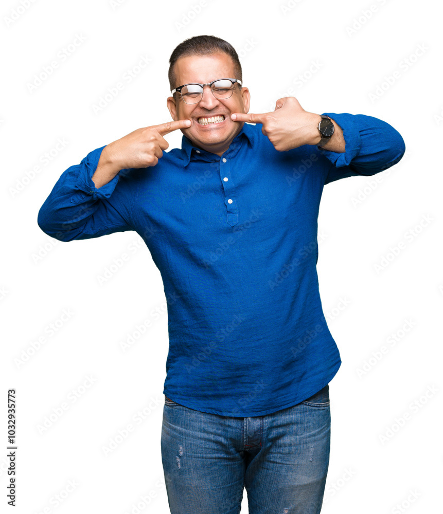 Middle age arab man wearing glasses over isolated background smiling confident showing and pointing with fingers teeth and mouth. Health concept. Middle age arab man wearing glasses over isolated background smiling confident showing and pointing with fingers teeth and mouth. Health concept.