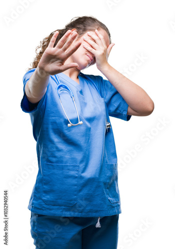 Young brunette doctor girl wearing nurse or surgeon uniform over isolated background covering eyes with hands and doing stop gesture with sad and fear expression. Embarrassed and negative concept.