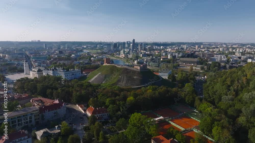 Aerial perspective of Vilnius, Lithuania, featuring Gediminas' Tower, lush greenery, and a blend of historical and modern architecture. Aerial perspective of Vilnius, Lithuania, featuring Gediminas' Tower, lush greenery, and a blend of historical and modern architecture.
