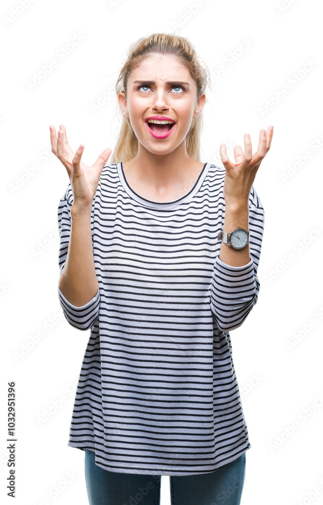 Young beautiful blonde woman wearing stripes sweater over isolated background crazy and mad shouting and yelling with aggressive expression and arms raised. Frustration concept. Young beautiful blonde woman wearing stripes sweater over isolated background crazy and mad shouting and yelling with aggressive expression and arms raised. Frustration concept.