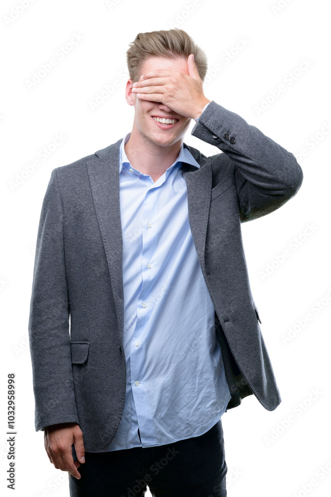 Young handsome blond business man smiling and laughing with hand on face covering eyes for surprise. Blind concept. Young handsome blond business man smiling and laughing with hand on face covering eyes for surprise. Blind concept.