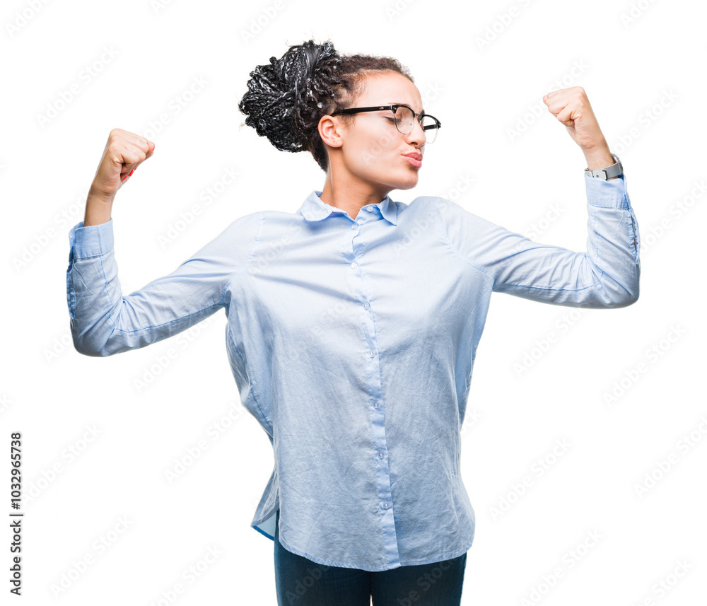 Young braided hair african american business girl wearing glasses over isolated background showing arms muscles smiling proud. Fitness concept.
