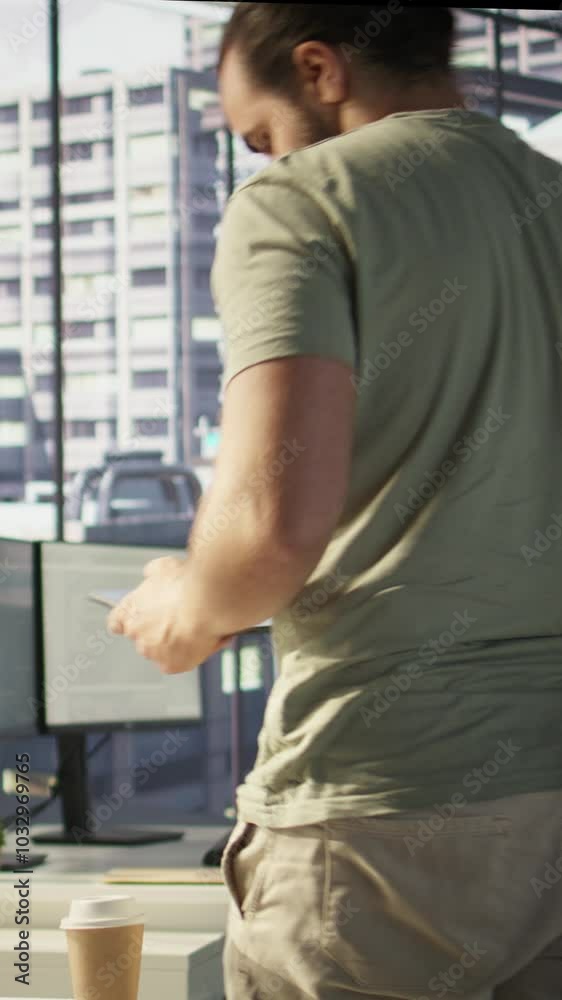 Vertical video System administrator checking results on tablet after creating complex machine learning models that can process and analyze vast amounts of data. Admin standing in office, looking at Vertical video System administrator checking results on tablet after creating complex machine learning models that can process and analyze vast amounts of data. Admin standing in office, looking at