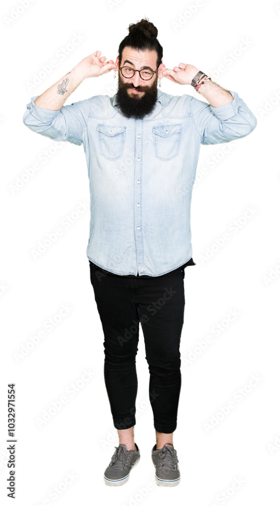 Young hipster man with long hair and beard wearing glasses Smiling pulling ears with fingers, funny gesture. Audition problem Young hipster man with long hair and beard wearing glasses Smiling pulling ears with fingers, funny gesture. Audition problem