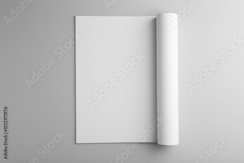 Open magazine with blank page on grey background, top view. Mockup for design