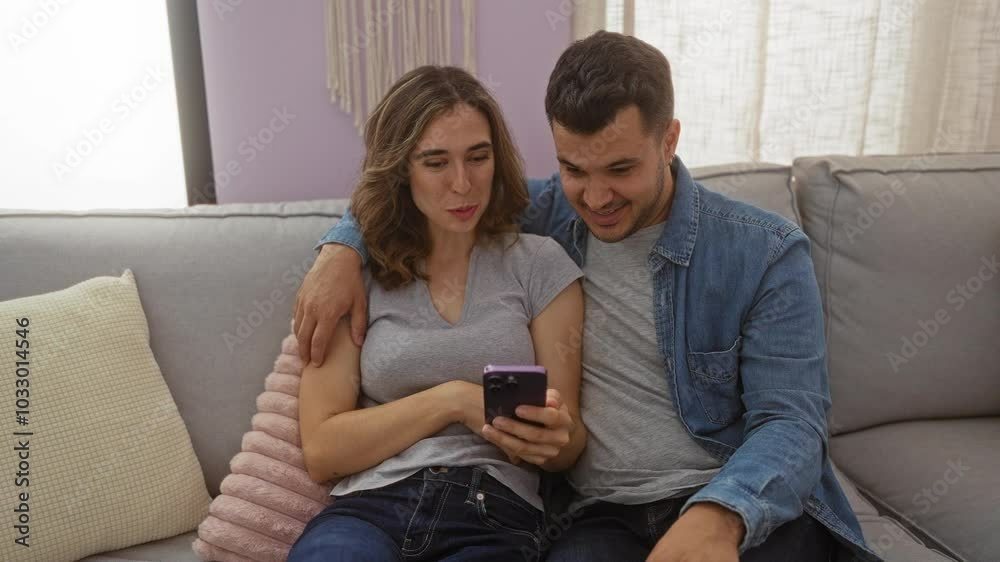 Woman and man enjoying time together with a smartphone in a cozy living room, laughing, and high-fiving, showcasing a modern relationship full of joy and love indoors. Woman and man enjoying time together with a smartphone in a cozy living room, laughing, and high-fiving, showcasing a modern relationship full of joy and love indoors.