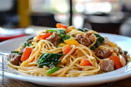 Close-up of a Plate of Stir-fried Noodles with Beef, Carrots, and Bell Peppers