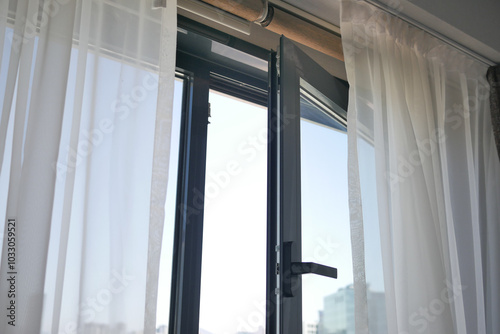 A Beautiful Sunlit Window Featuring Sheer Curtains in a Contemporary and Modern Room