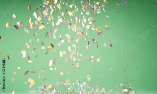 Golden and silver confetti pieces gently drifting down in a spiral pattern, glittering as they move, displayed on a green screen background.