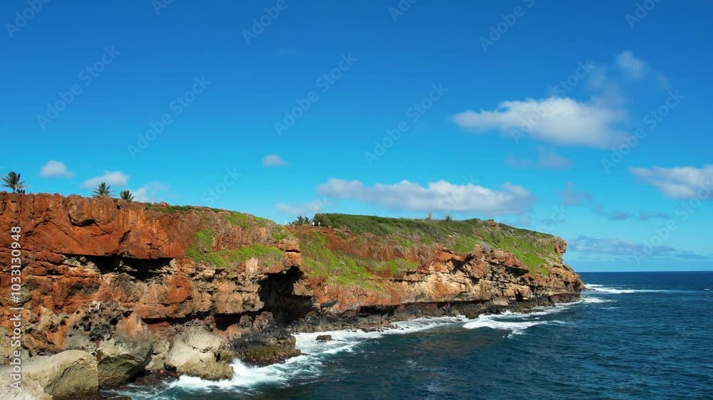 A low angle drone shot from the ocean approaching a Hawaiian cliffside. A low angle drone shot from the ocean approaching a Hawaiian cliffside.