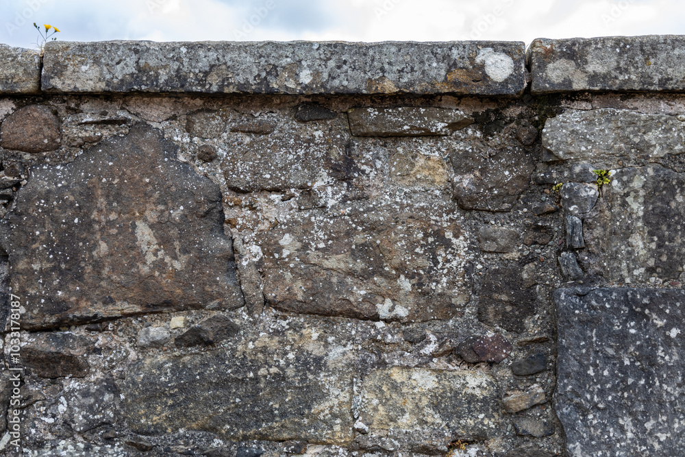 Fototapeta premium Full frame abstract texture background of a rugged medieval stone wall circa 16th century, with copy space