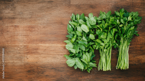 Fresh green herbs arranged neatly on a wooden surface, showcasing vibrant leaves and sturdy stems perfect for culinary use.