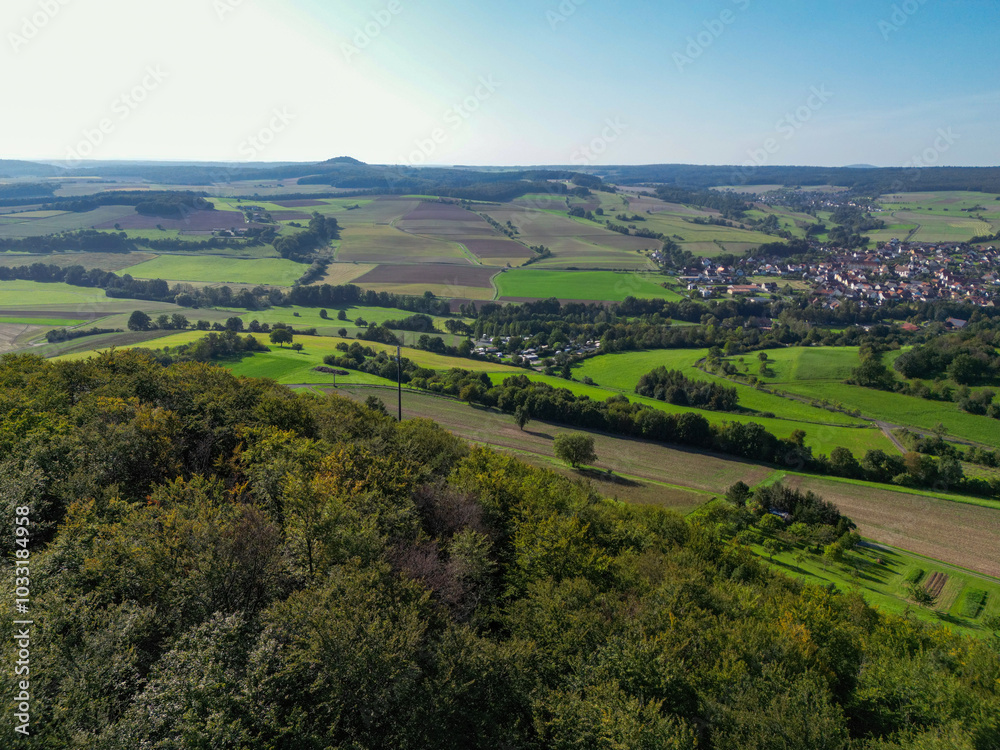 Obraz premium Luftaufnahme, Drohnenfoto der fränkischen Landschaft bei Hammelburg, Bad Kissingen im Sommer mit blauem Himmel, von oben, Vogelperspektive, Thulba, Franken, Bayern, Deutschland 