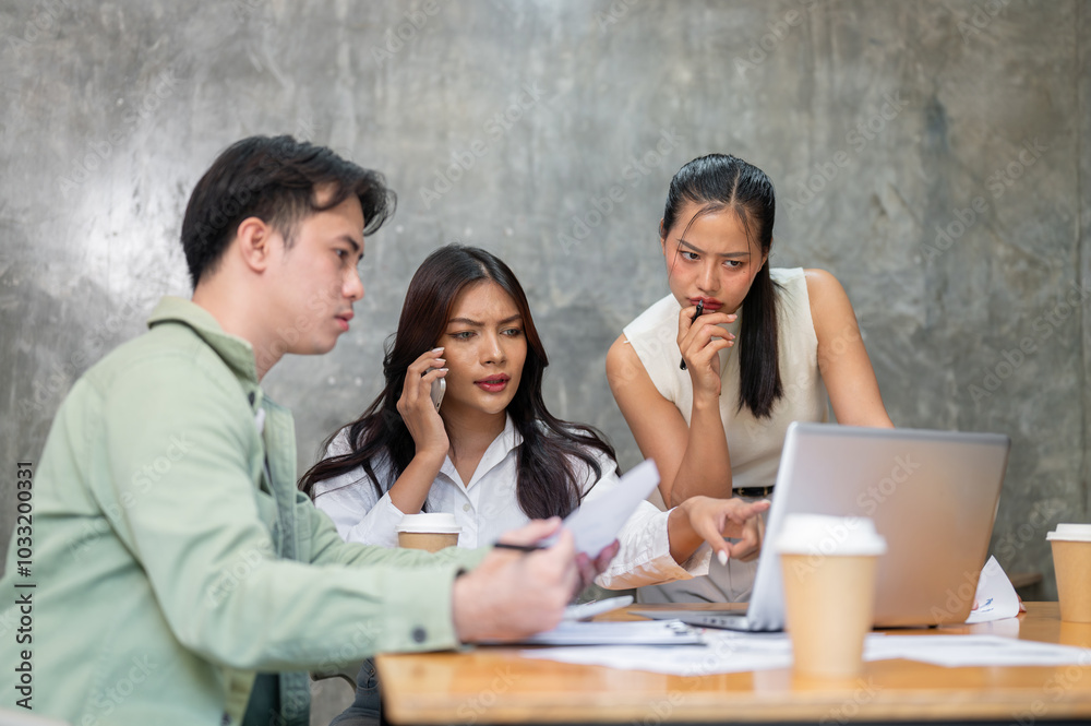 A group of serious, stressed Asian businesspeople is having an intense meeting. A group of serious, stressed Asian businesspeople is having an intense meeting.