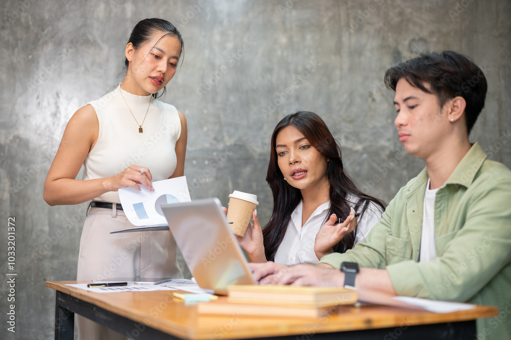 A team of professional young Asian startup members is having a serious meeting to plan a project. A team of professional young Asian startup members is having a serious meeting to plan a project.