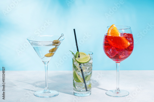 A variety of cocktails arranged on a table against a light blue background