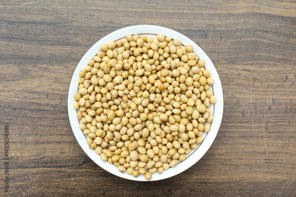 Soybean seeds in a plate on wooden background Soybean seeds in a plate on wooden background