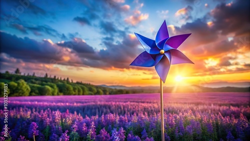 Paper windmill on blue stick in purple flowers field at sunset