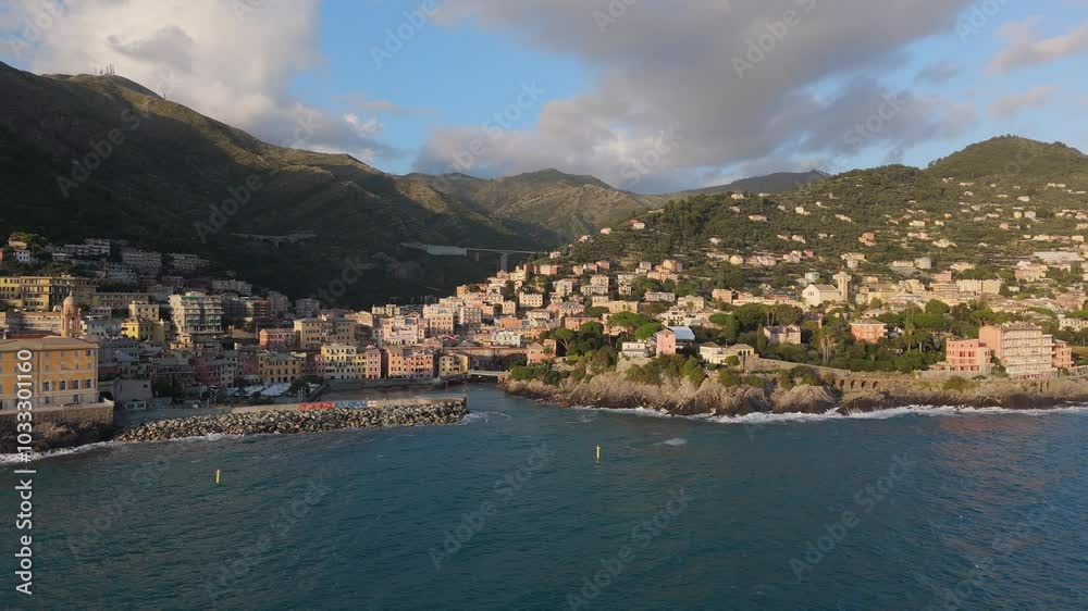 A coastal town in Genoa with colorful houses and scenic hills by the blue sea at sunset A coastal town in Genoa with colorful houses and scenic hills by the blue sea at sunset
