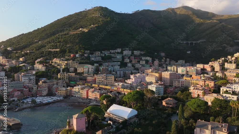 Colorful coastal town with hilly backdrop and small port by the sea at sunset, aerial view Colorful coastal town with hilly backdrop and small port by the sea at sunset, aerial view