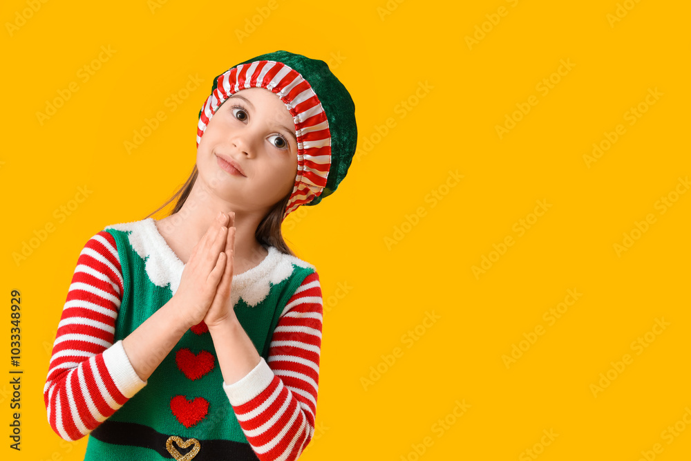 Cute little girl in elf's costume on yellow background Cute little girl in elf's costume on yellow background