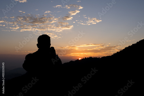 Beautiful sunrise with the silhouette of people and mountain landscape shot. 