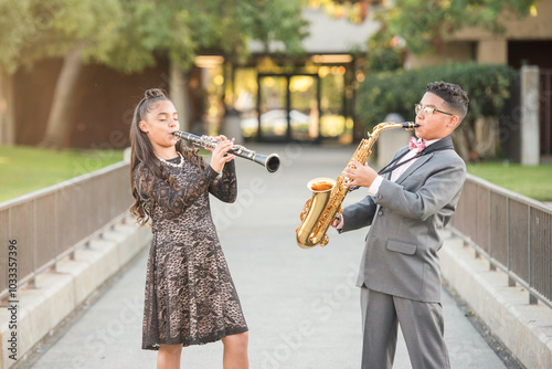 Twins playing their instraments together outside