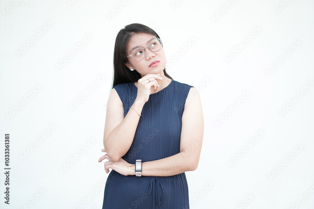 Beautiful Asian woman looks upward with a thoughtful expression, making a thinking gesture on a white background