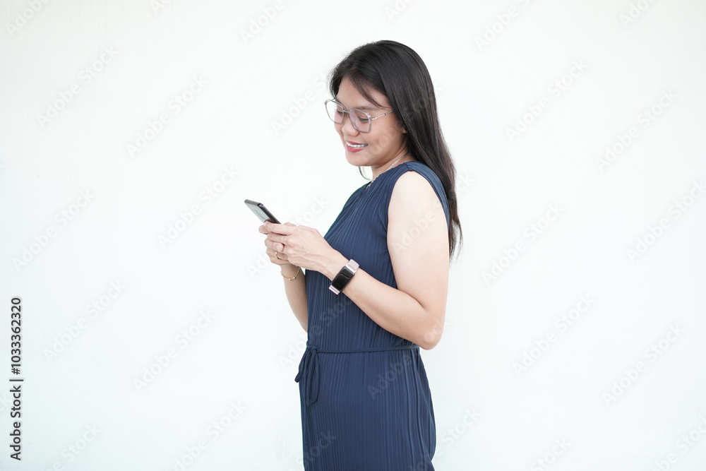 Beautiful Asian woman smiles while holding a smartphone, radiating positivity against a white background Beautiful Asian woman smiles while holding a smartphone, radiating positivity against a white background