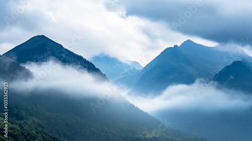 Misty mountains shrouded in clouds create a serene and atmospheric landscape.