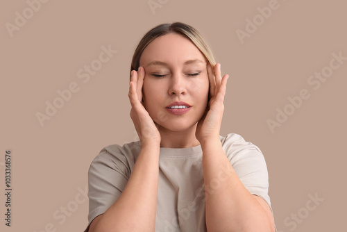 Slika na platnu Woman doing face building exercise on beige background