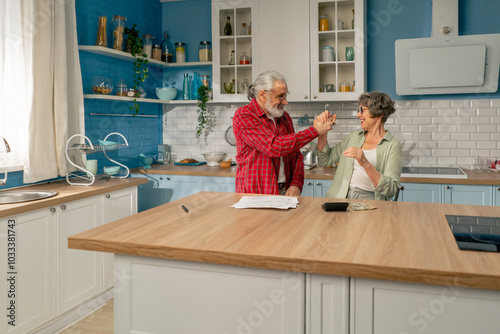 in bright kitchen an elderly cute couple at the table count their expenses monthly payment summing up the results of the year utilities count monthly survival count money photo