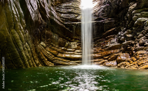 Fototapeta Naklejka Na Ścianę i Meble -  A waterfall is flowing into a pool of water
