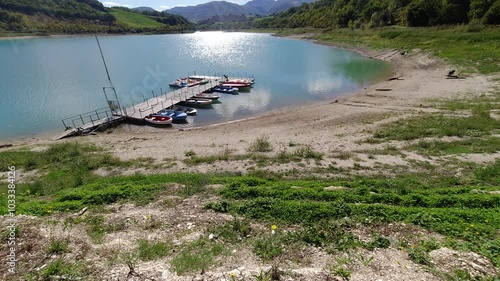 timelapse lago con barche da pesca, montagne e tempo soleggiato