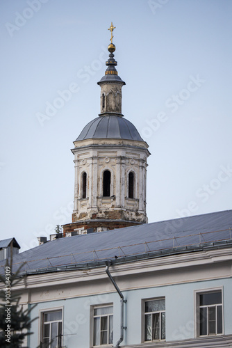 A tall building with a steeple and a cross on top