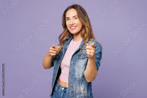 Young woman she wear denim jacket violet top casual clothes point index finger camera on you motivating encourage isolated on plain pastel light purple background studio portrait. Lifestyle concept.